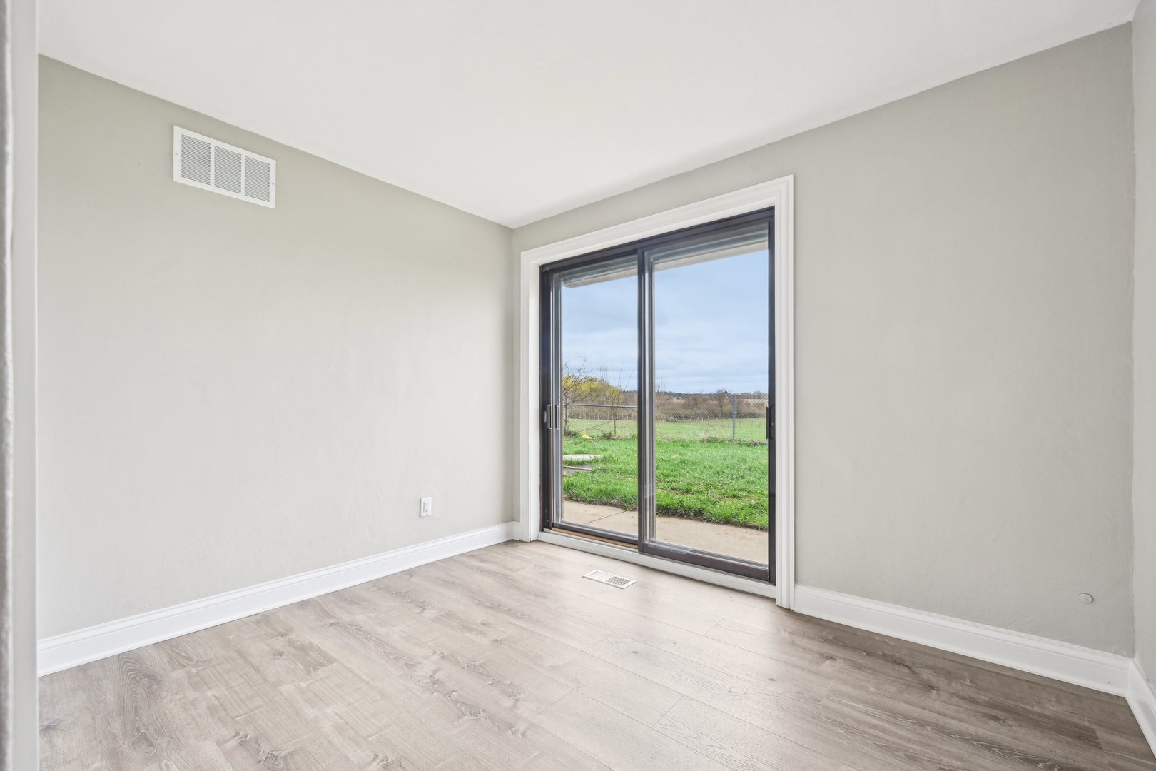 1406 Busse Road Marengo, IL 60152 - Photo 25 of 76 a view of an empty room with wooden floor and a window