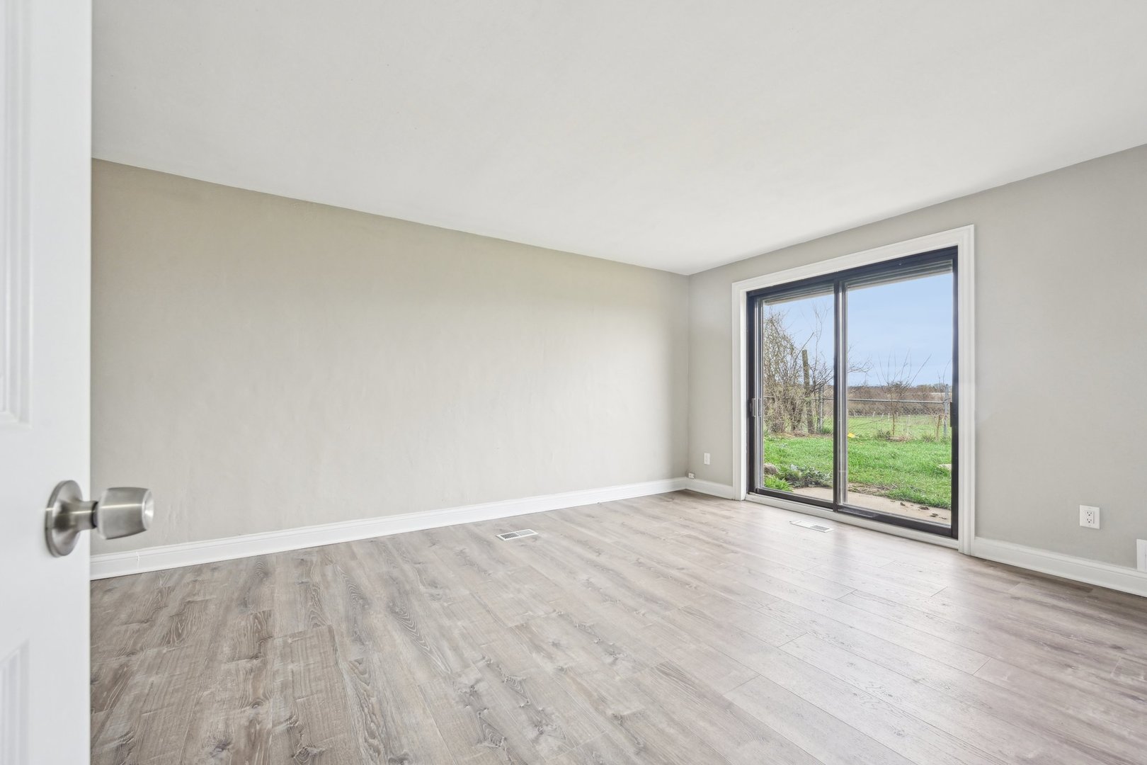 1406 Busse Road Marengo, IL 60152 - Photo 29 of 76 a view of an empty room with wooden floor and a window