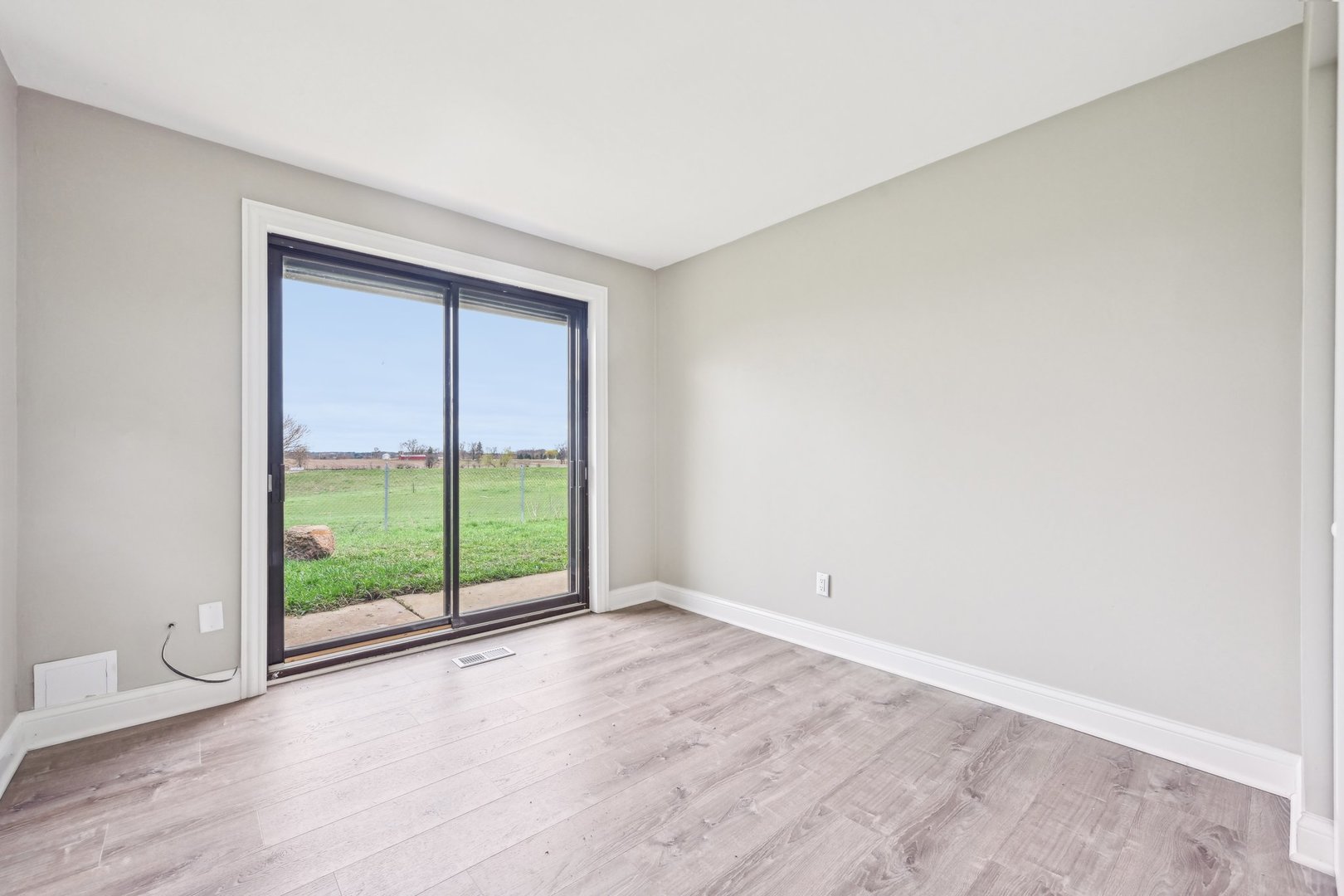 1406 Busse Road Marengo, IL 60152 - Photo 39 of 76 a view of an empty room with wooden floor and a window