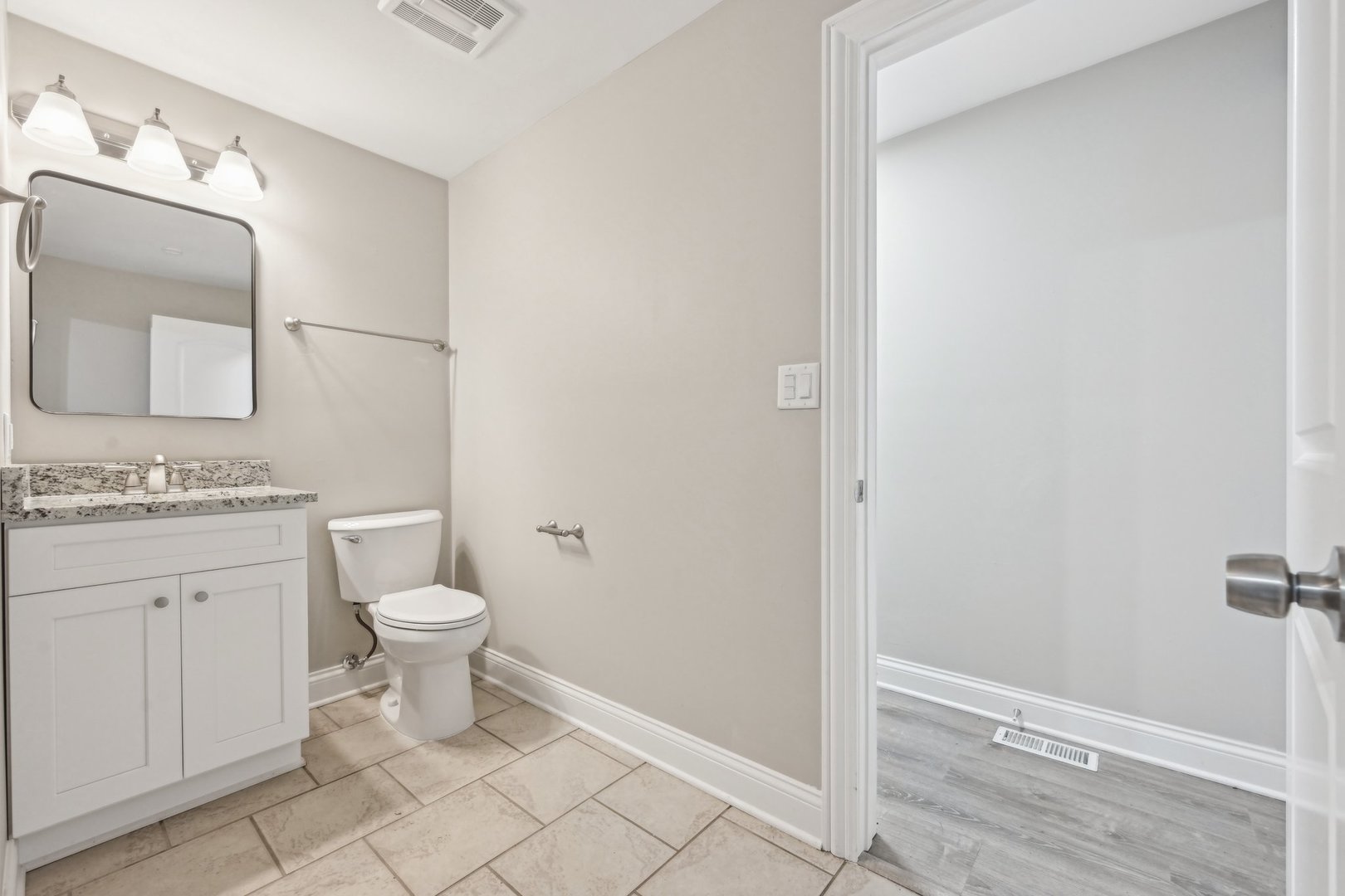 1406 Busse Road Marengo, IL 60152 - Photo 42 of 76 a bathroom with a granite countertop toilet a sink and a mirror