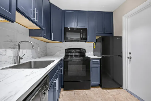 a kitchen with granite countertop wooden cabinets stainless steel appliances and a sink
