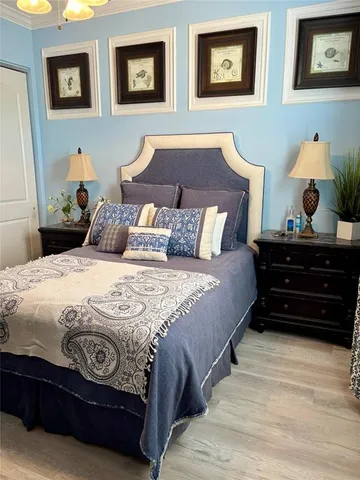 a bedroom with a bed and painting on the wall