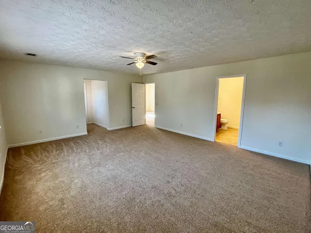 an empty room with windows and ceiling fan view