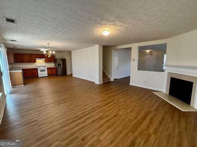 a view of empty room with wooden floor and fireplace