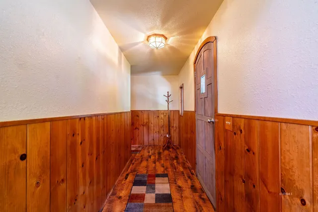 a view of a hallway with wooden floor and stairs