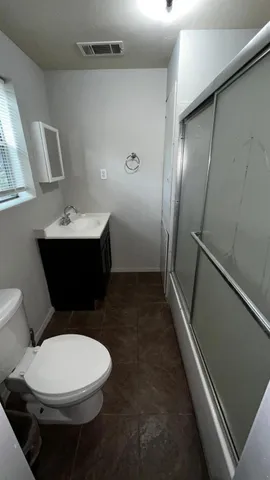 a bathroom with a toilet sink and mirror