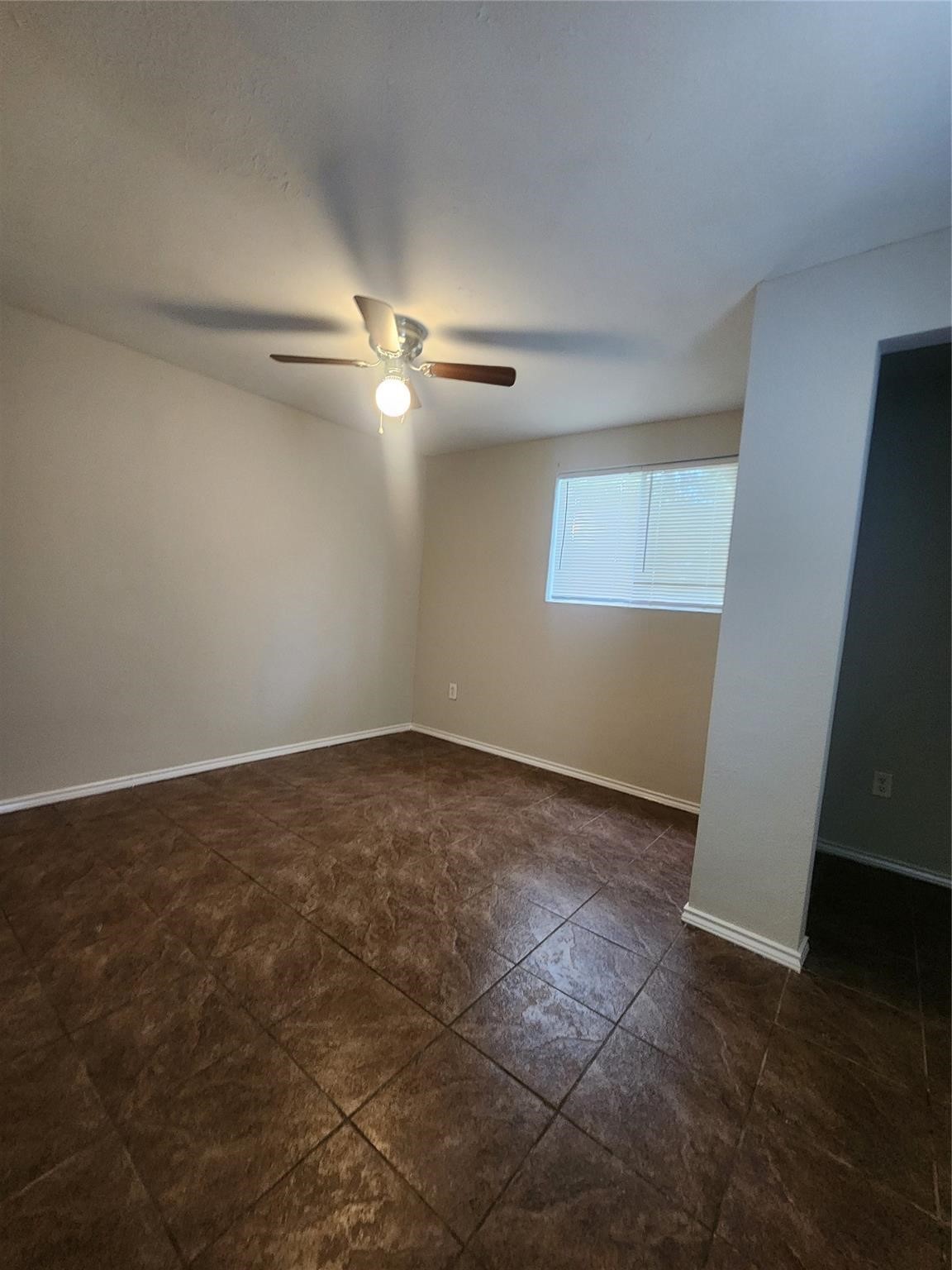 221 East Lobit Avenue, Unit A Baytown, TX 77520 - Photo 5 of 6 an empty room with wooden floor fan and window