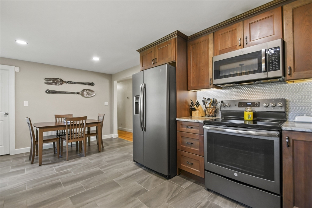 293 Harrington Way Worcester, MA 01604 - Photo 7 of 29 a kitchen with stainless steel appliances granite countertop a refrigerator stove top oven dining table and chairs