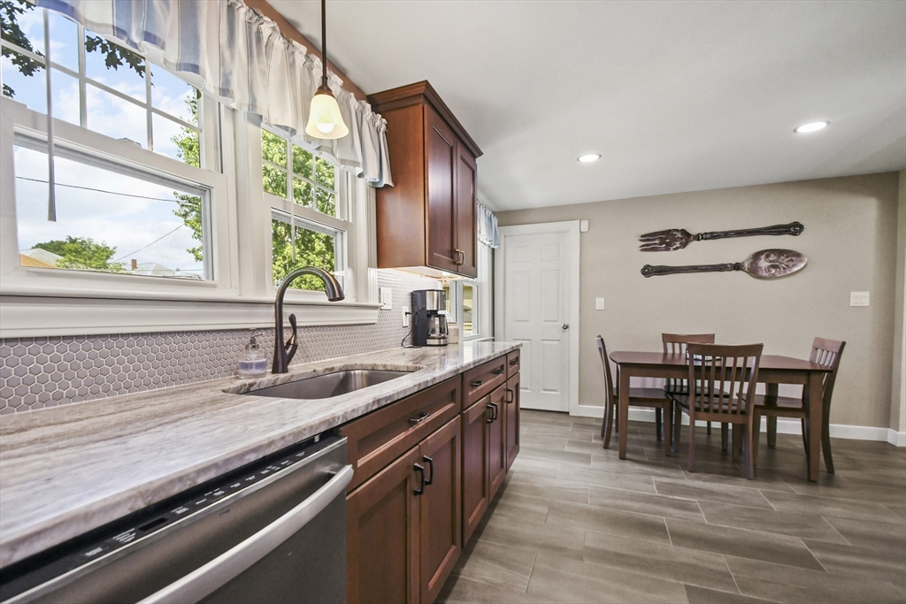 293 Harrington Way Worcester, MA 01604 - Photo 8 of 29 a kitchen with kitchen island granite countertop a sink and a large window