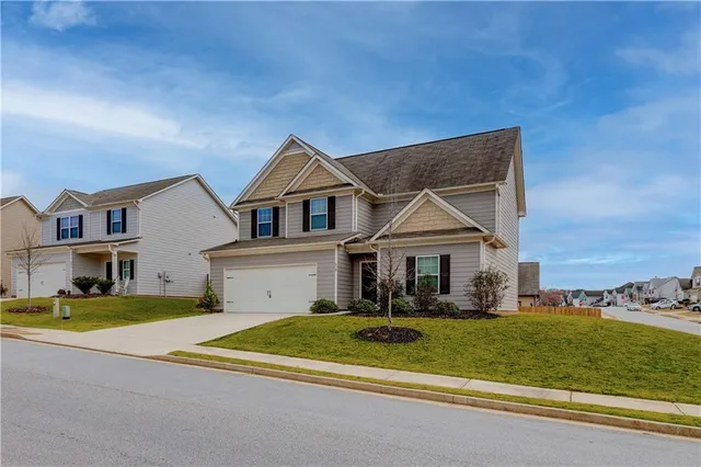 a view of a house with a big yard and large trees