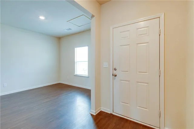 an empty room with wooden floor and closet