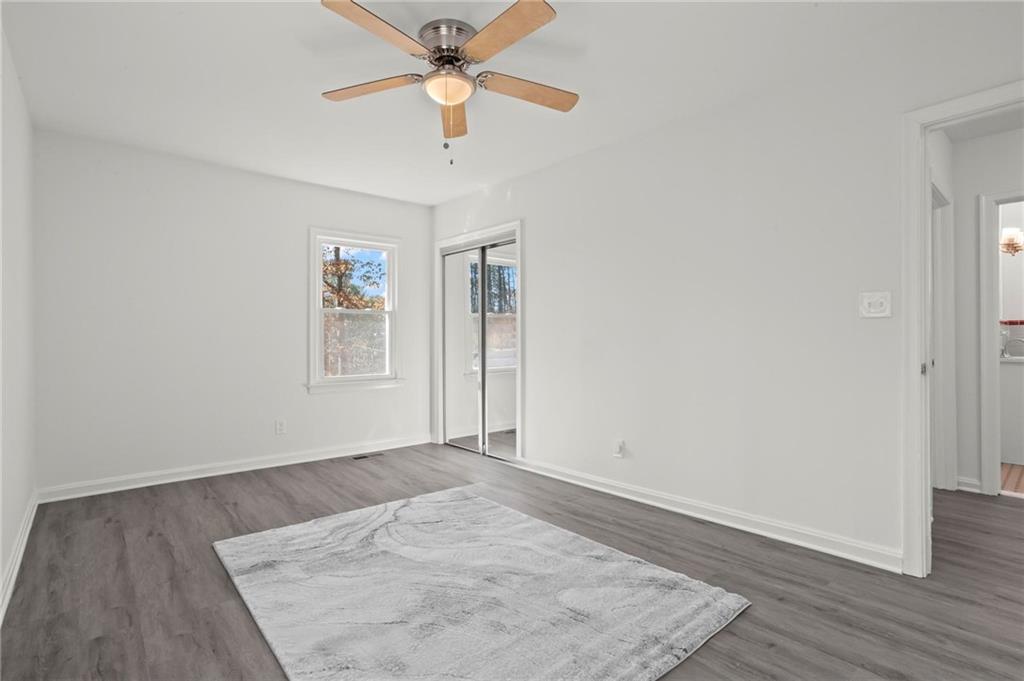 502 Alpine Way Marietta, GA 30062 - Photo 17 of 21 an empty room with wooden floor chandelier fan and windows