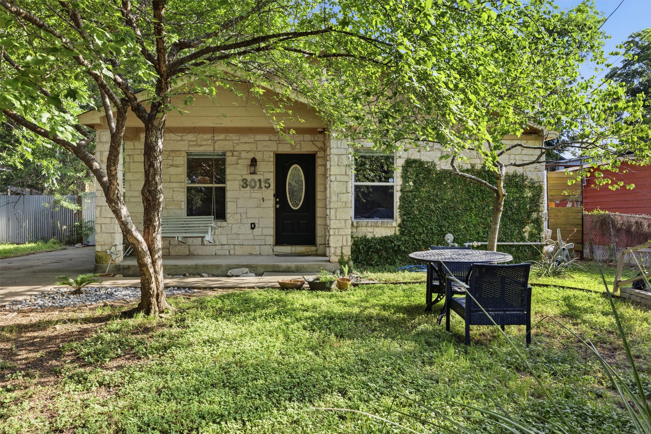 A charming stone facade home nestled amidst verdant landscaping.