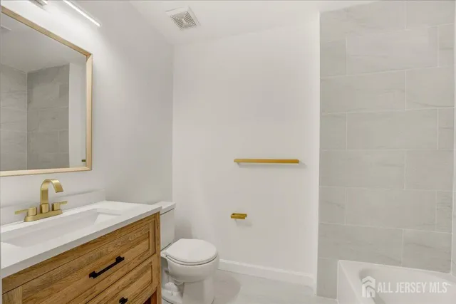 a bathroom with a sink a toilet and a mirror