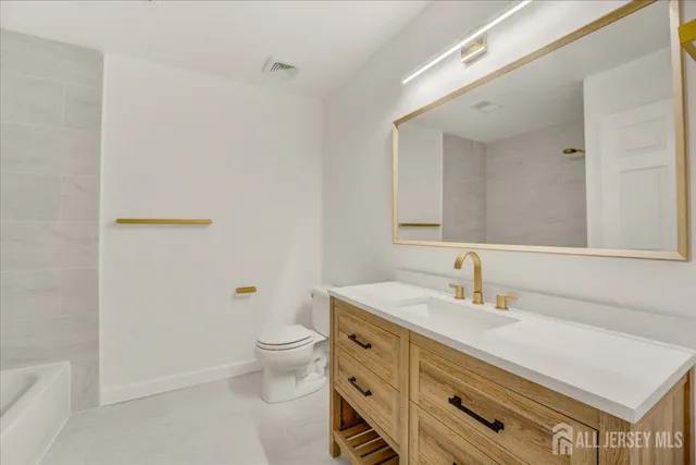 a bathroom with a sink a toilet and a mirror