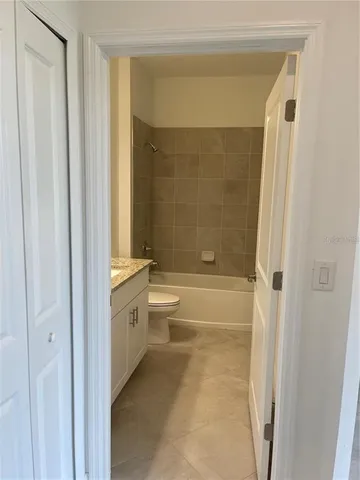 a bathroom with a granite countertop bathtub shower sink and toilet
