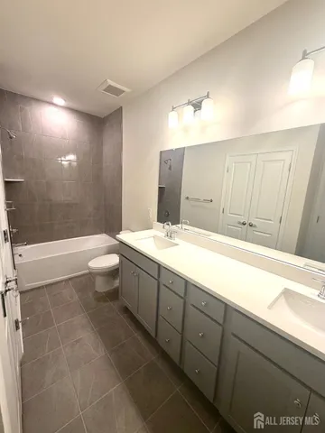 a bathroom with a sink a toilet a mirror and bathtub