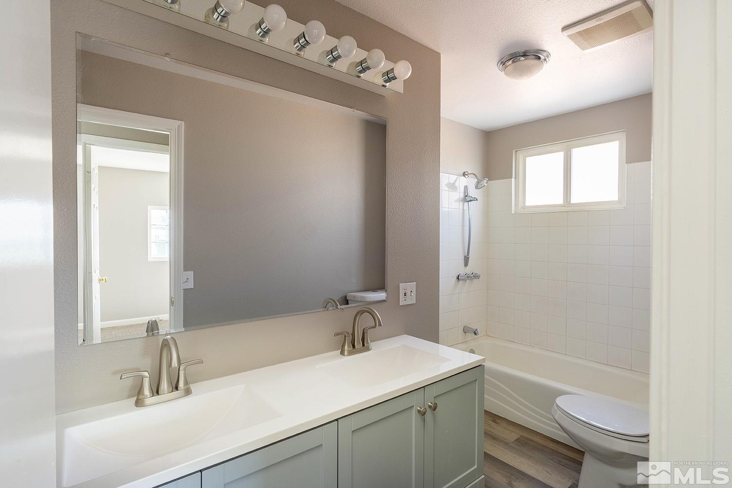 16310 Enargite Circle Reno, NV 89521 - Photo 19 of 32 a bathroom with a sink a toilet a mirror and shower