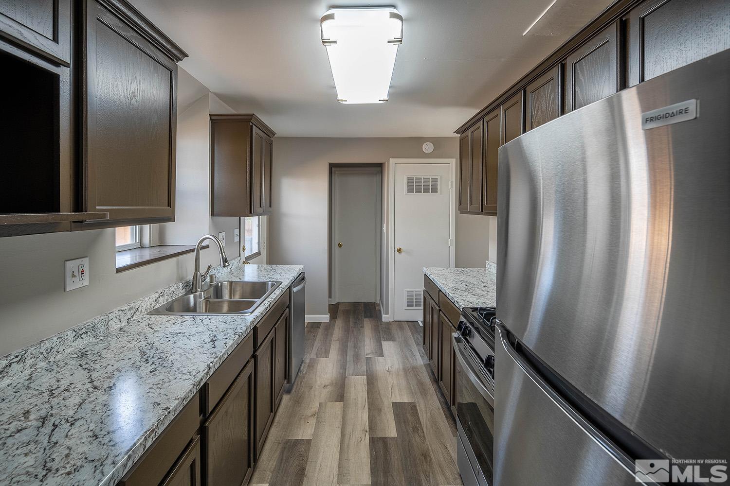 16310 Enargite Circle Reno, NV 89521 - Photo 3 of 32 a kitchen with granite countertop a refrigerator a sink and dishwasher