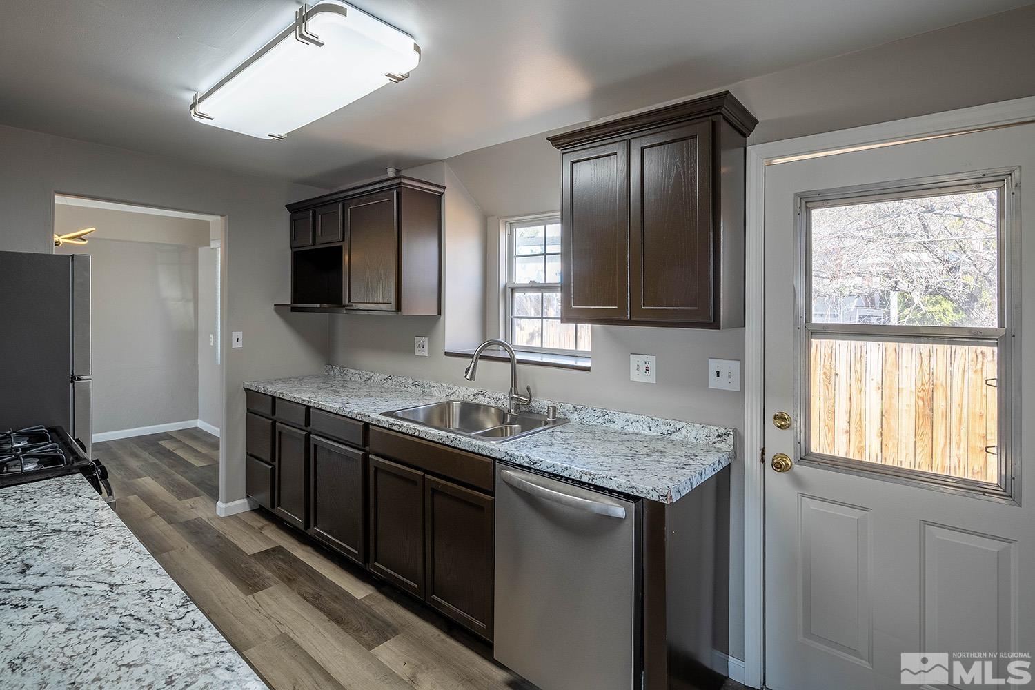 16310 Enargite Circle Reno, NV 89521 - Photo 4 of 32 a kitchen with a granite countertop sink stove and refrigerator