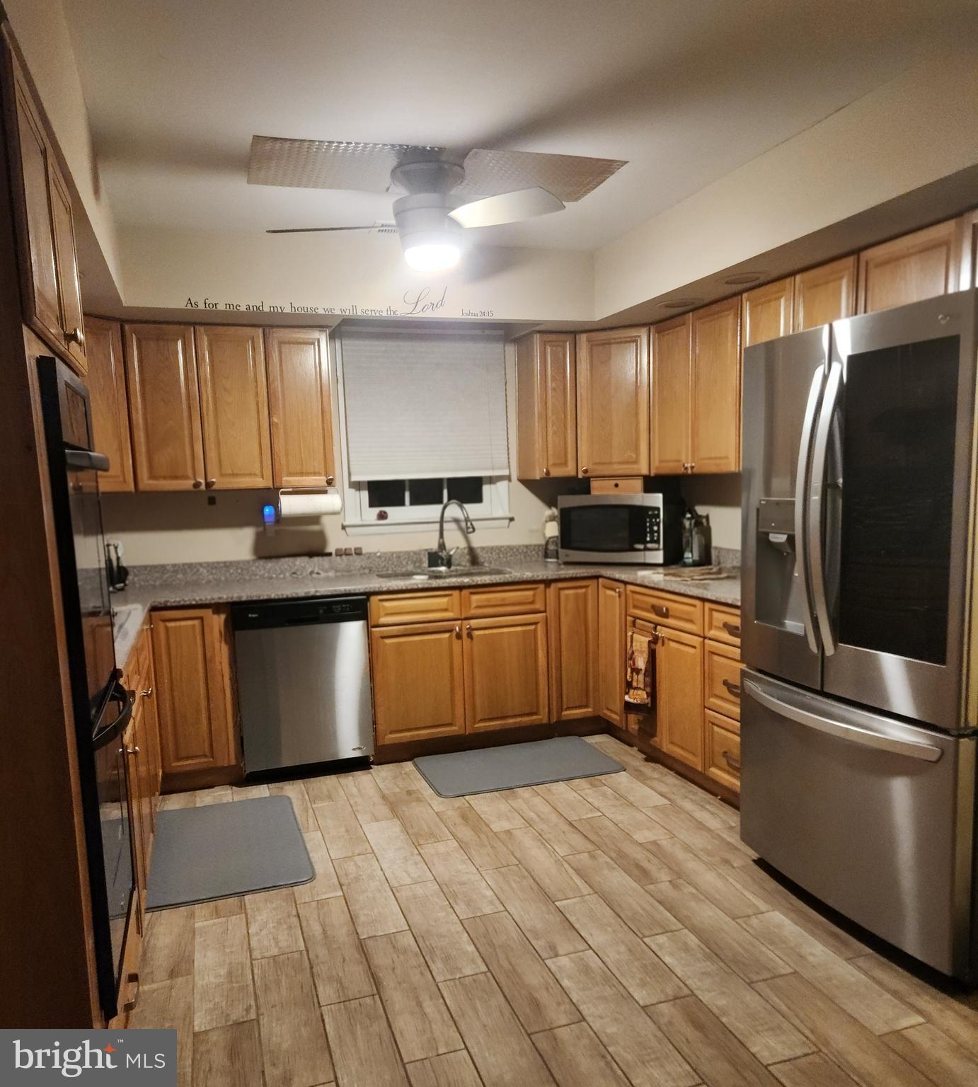 6810 Robinia Road Temple Hills, MD 20748 - Photo 8 of 15 a kitchen with stainless steel appliances granite countertop a sink a stove a refrigerator cabinets and wooden floor