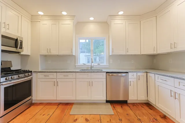 a kitchen with stainless steel appliances granite countertop a refrigerator and a stove top oven