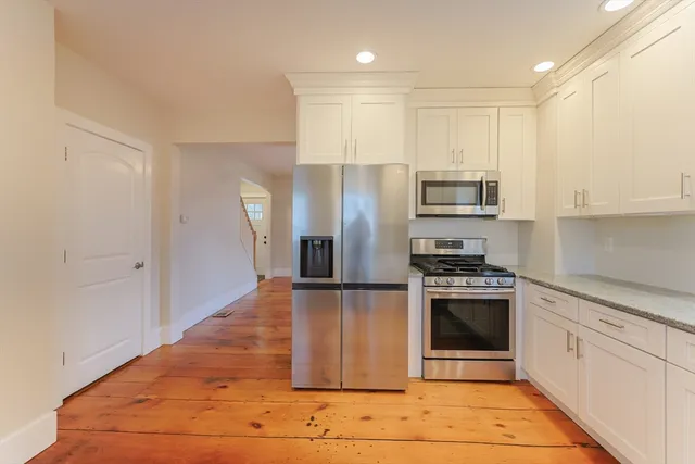 a large kitchen with stainless steel appliances granite countertop a stove and a refrigerator