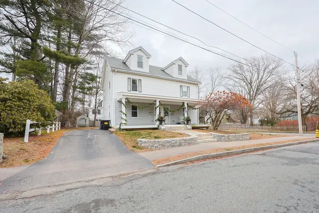 a view of a white house with a large tree