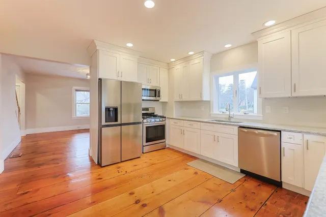 a kitchen with granite countertop white cabinets and white appliances
