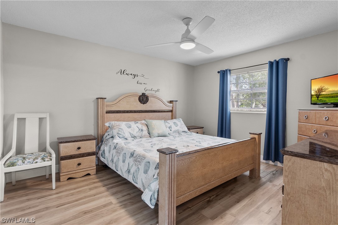 7031 New Post Road, Unit 4 North Fort Myers, FL 33917 - Photo 11 of 39 a bedroom with a bed and a flat tv screen on dresser