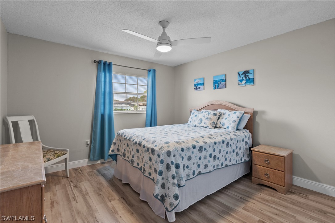 7031 New Post Road, Unit 4 North Fort Myers, FL 33917 - Photo 16 of 39 a bedroom with a large bed and a wooden floor