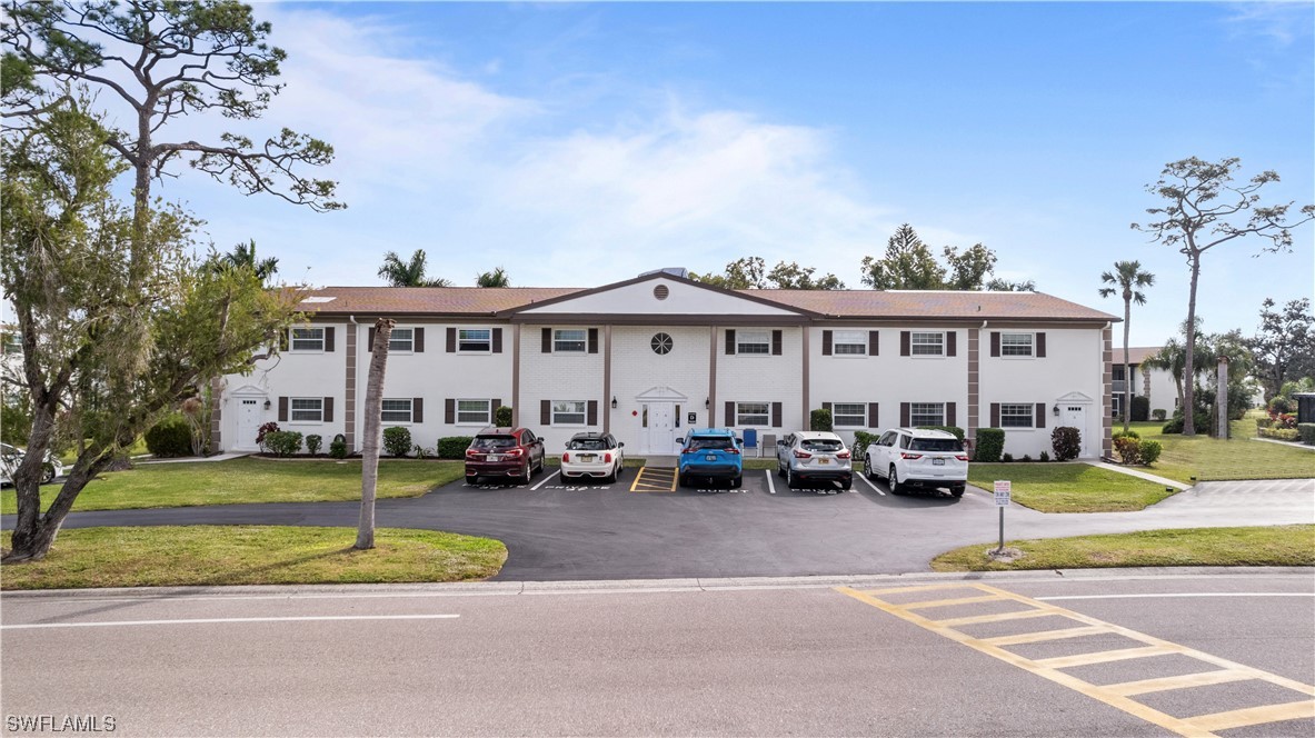 7031 New Post Road, Unit 4 North Fort Myers, FL 33917 - Photo 30 of 39 a view of a white house with a swimming pool yard and a table and chairs