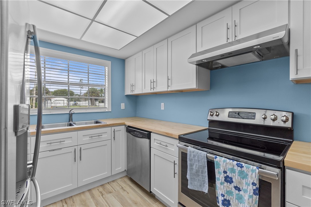 7031 New Post Road, Unit 4 North Fort Myers, FL 33917 - Photo 3 of 39 a kitchen with a stove microwave and sink