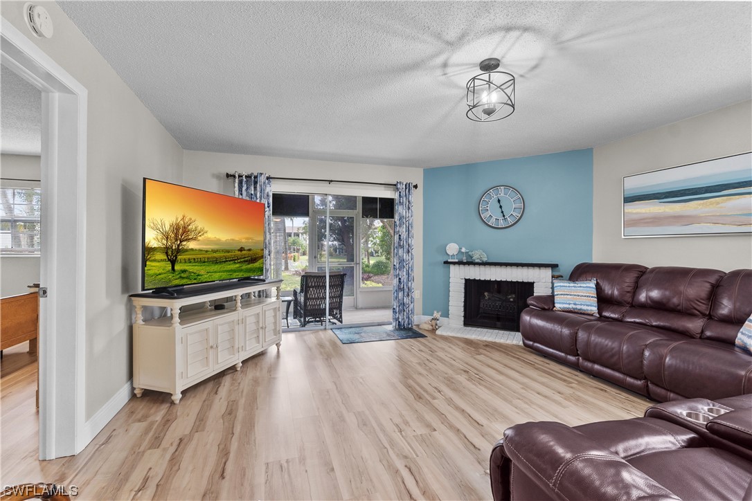7031 New Post Road, Unit 4 North Fort Myers, FL 33917 - Photo 8 of 39 a living room with furniture a flat screen tv and a fireplace