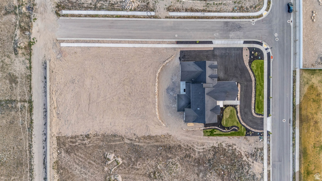 2828 Jojo Road Eagle Mountain, UT 84005 - Photo 63 of 63 Newly constructed residence featuring a dark shingle roof, established landscaping, paved driveway, and concrete sidewalk