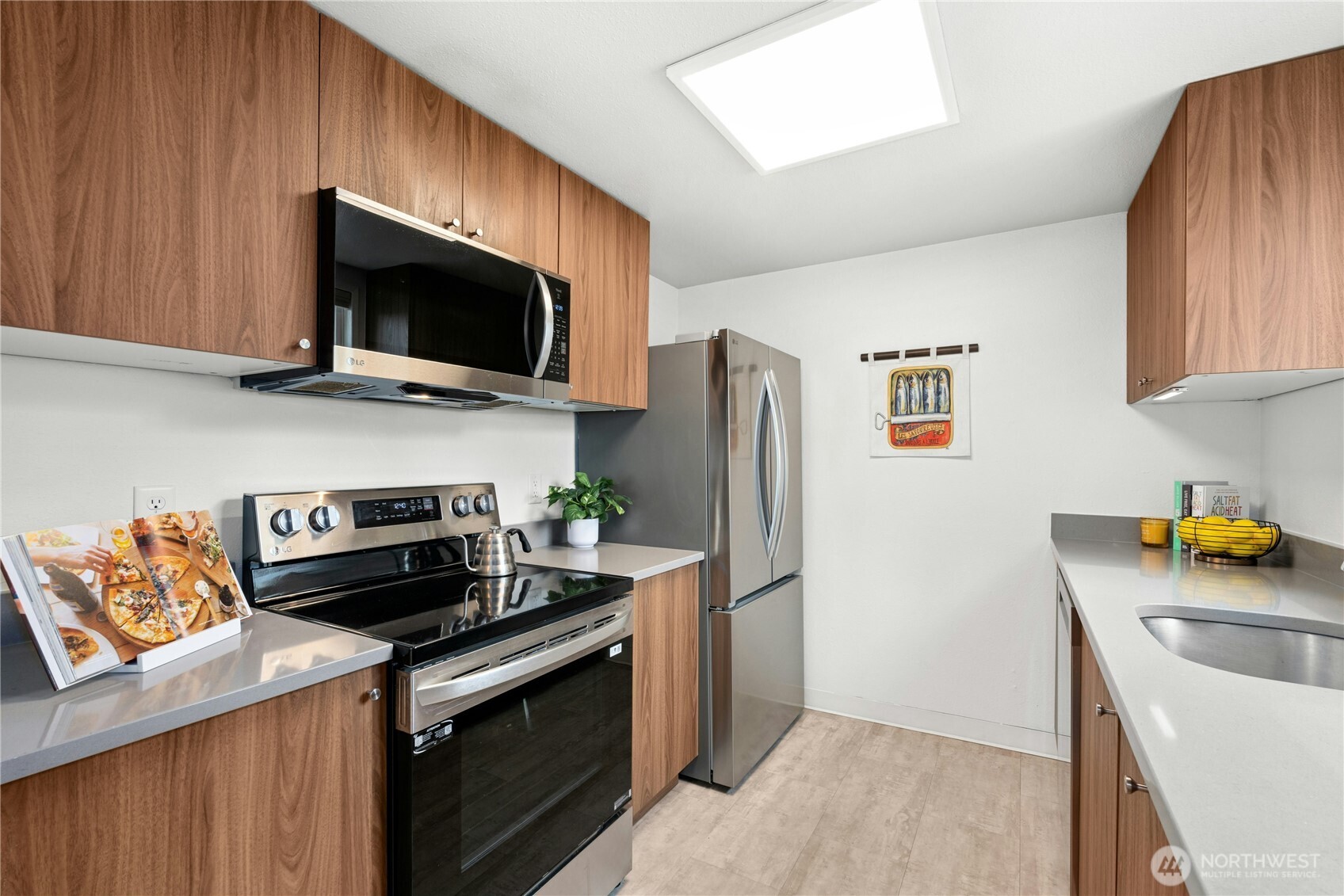 9523 Northeast 180th Street, Unit A102 Bothell, WA 98011 - Photo 11 of 29 a kitchen with stainless steel appliances a stove microwave and refrigerator