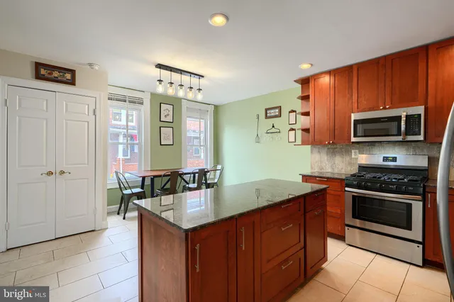 a kitchen with stainless steel appliances a stove sink and microwave