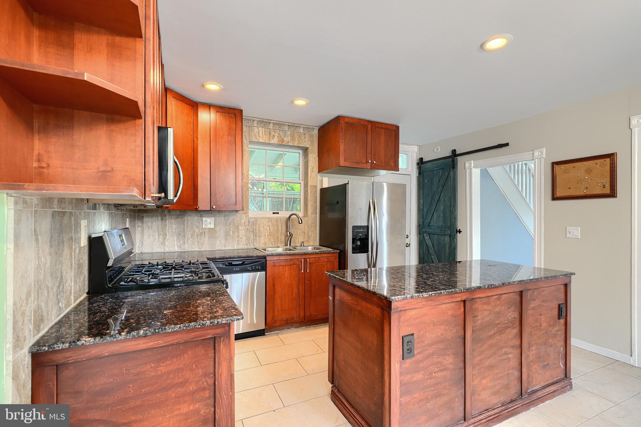 620 Montpelier Street, Unit 1 Baltimore, MD 21218 - Photo 13 of 29 a kitchen with stainless steel appliances granite countertop a stove a sink and a refrigerator
