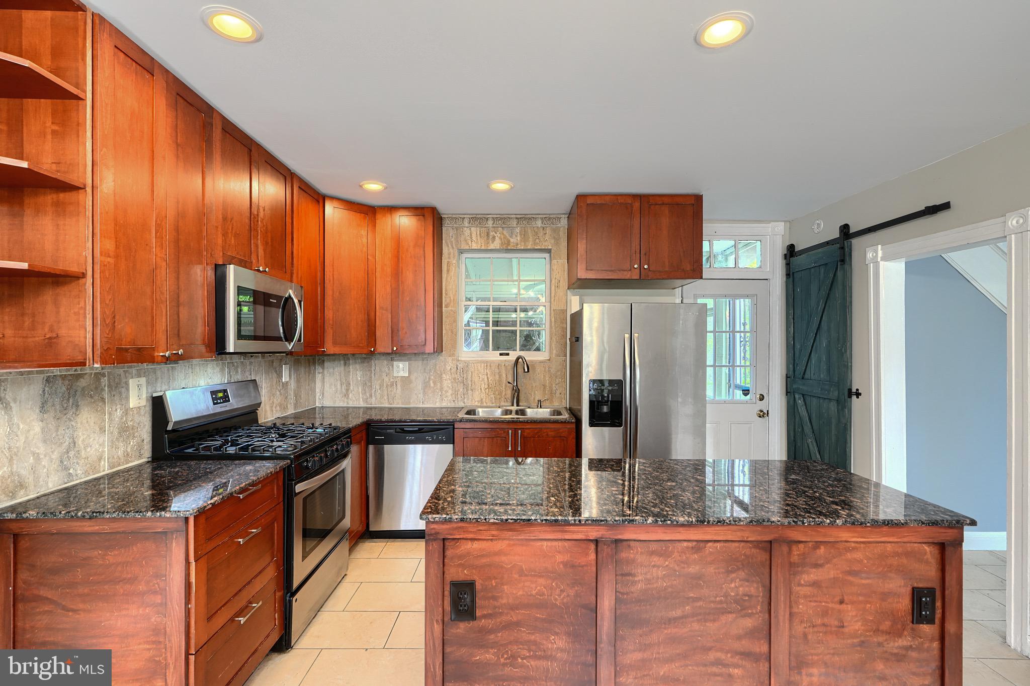 620 Montpelier Street, Unit 1 Baltimore, MD 21218 - Photo 14 of 29 a kitchen with stainless steel appliances granite countertop wooden cabinets a stove top oven a sink and dishwasher