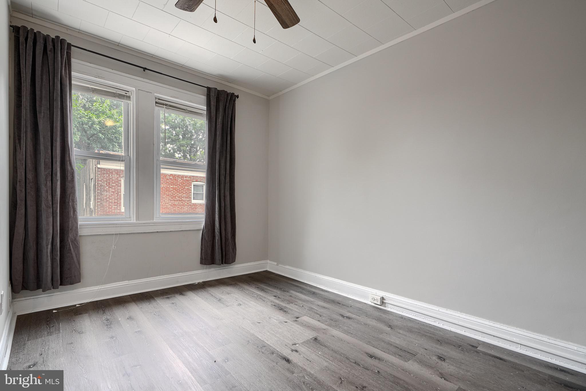 620 Montpelier Street, Unit 1 Baltimore, MD 21218 - Photo 26 of 29 an empty room with wooden floor and windows