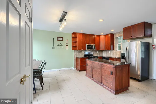 a kitchen with stainless steel appliances granite countertop a refrigerator and a stove top oven