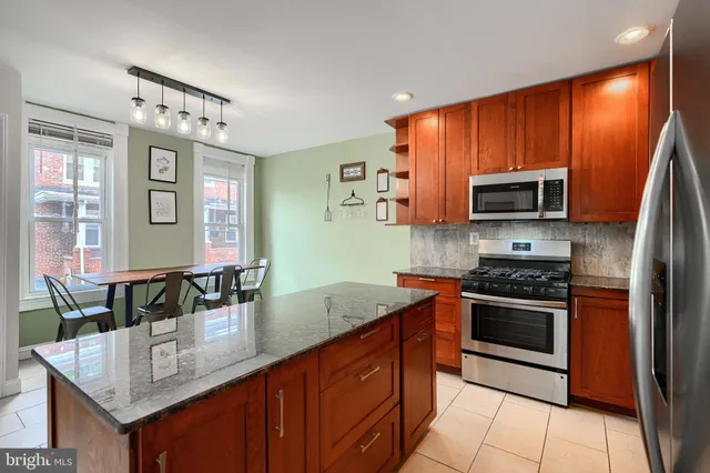 a kitchen with stainless steel appliances granite countertop a stove microwave and sink