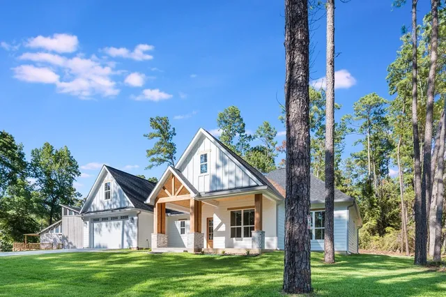 a front view of a house with a garden and trees