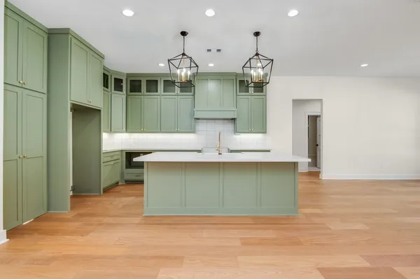a kitchen with kitchen island a sink and wooden floors