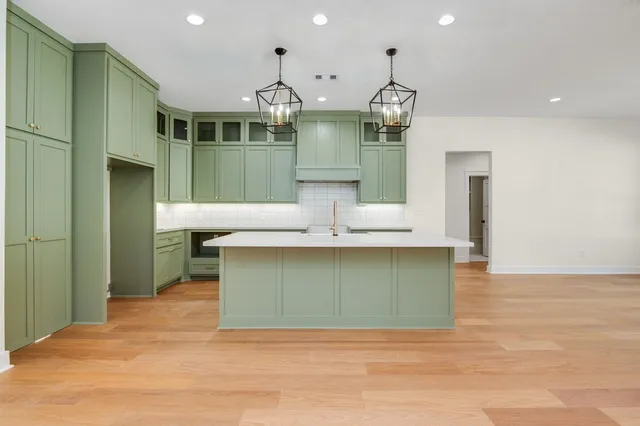 a kitchen with kitchen island a sink and wooden floors