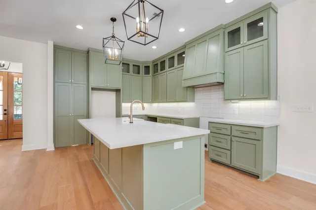 a kitchen with a sink a cabinets and wooden floor