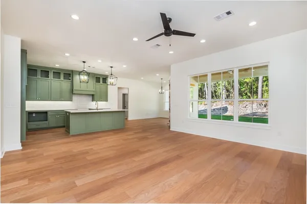 a view of an empty room with a kitchen and a sink