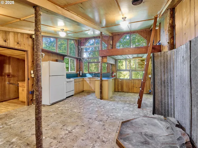 a kitchen with stainless steel appliances wooden cabinets a stove and a large window