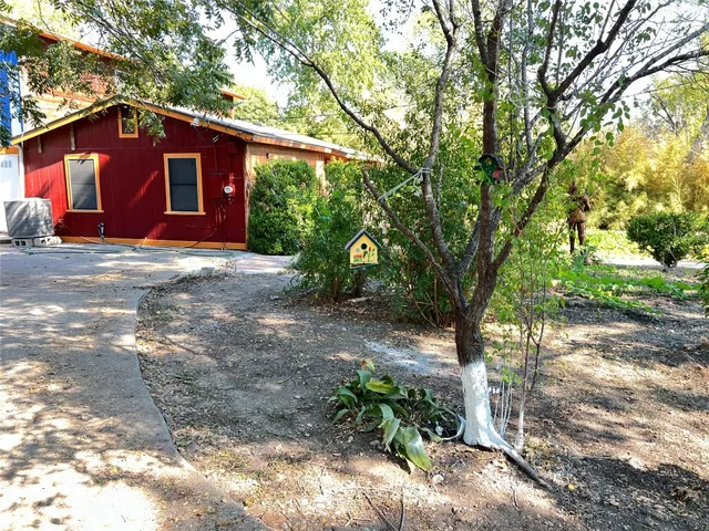 a view of a barn house with a large tree