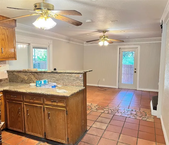 a kitchen with kitchen island granite countertop a stove a sink and a cabinets